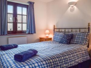 um quarto com uma cama com almofadas azuis em Honeysuckle Cottage em Mickleton