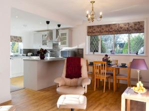 a kitchen and living room with a table and a chair at Alices Lodge in Ringwood