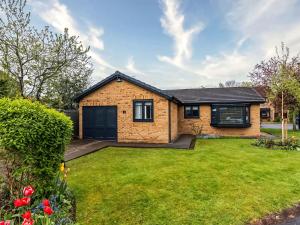 a brick house with a lawn in front of it at Plum Tree House in Dore