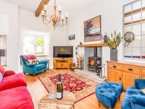 a living room with a red couch and blue chairs at The Farmhouse - Uk33419 in West Witton