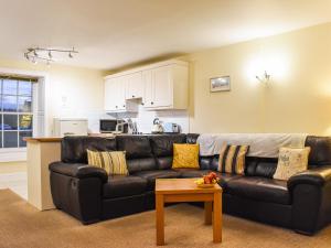 ein Wohnzimmer mit einem schwarzen Ledersofa und einem Tisch in der Unterkunft Baileys Retreat in Sneaton