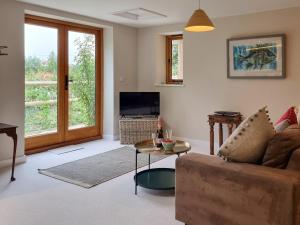 a living room with a couch and a table at The Stables in Mudford