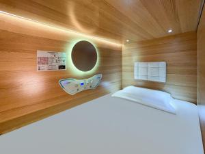 um pequeno quarto com uma cama e uma parede de madeira em Airone Capsule Hotel em Hobart