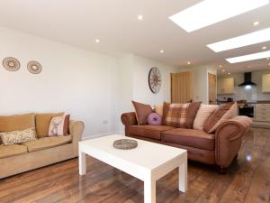 Sala de estar con 2 sofás y mesa en Breckland Cottage, en Hockwold cum Wilton