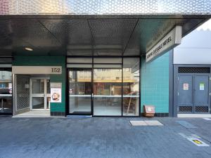 an empty building with glass doors on a street at Airone Capsule Hotel in Hobart