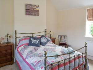 a bedroom with a bed with blue pillows on it at The Coach House in Great Ryburgh