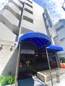 um guarda-chuva azul em frente a um edifício em E Hotel Warabi em Warabi