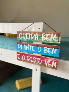 una pila de libros en una cama con un cartel en Casa_praia_Laphina - Frente do mar com piscina! en Guarapari
