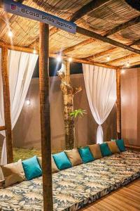 Una cama con almohadas y un árbol en una habitación en Casa_praia_Laphina - Frente do mar com piscina! en Guarapari