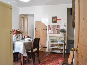 a dining room with a table and a table and chairs at The Old Laundry Cottage in Hythe