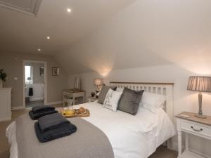 Un dormitorio con una cama blanca con toallas. en River Quay, en Gorleston-on-Sea