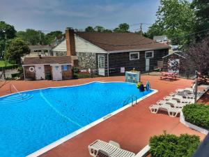 
a swimming pool with a pool table and chairs at Budget Host East End Hotel in Riverhead in Riverhead
