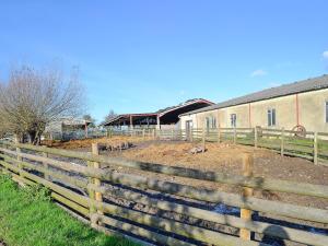 a wooden fence in front of a building at The Hay Barn - Ukc4135 in Arlingham