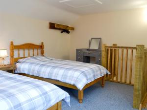 1 dormitorio con 2 camas y vestidor en Snipelands Barn, en Wedmore