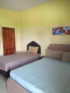 1 dormitorio con 2 camas y puerta en Sabuydee Place Chiang Rai, en Chiang Rai