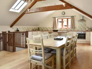 Wriggle View - Dbbm في Leigh: مطبخ وغرفة طعام مع طاولة وكراسي خشبية