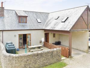 ein Haus mit einem Steinzaun davor in der Unterkunft 2 Sawmill Cottages in Puncknowle