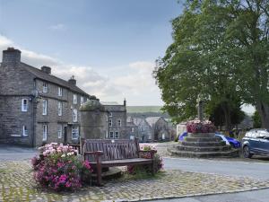 a park bench next to a fountain in a town at Skellgill Barn in Bainbridge