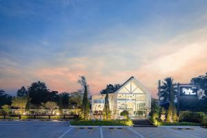 Watthana Nakhon的住宿－Picha Ville Resort，黄昏时停车场的一座建筑