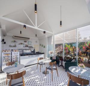 a restaurant with tables and chairs and a counter at Picha Ville Resort in Watthana Nakhon