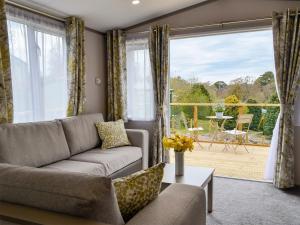 a living room with a couch and a large window at Kipp Away in Kippford