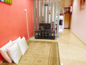a living room with a couch and a television at D'LAILA HOMESTAY in Kampong Gelegoh Lama