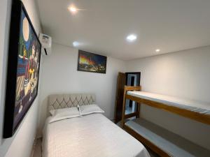 ein kleines Schlafzimmer mit einem Bett und einem Regal in der Unterkunft RECANTO RESIDENCIAL MARISCAL APT03 in Bombinhas