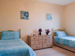 1 dormitorio con 2 camas y vestidor con flores en Bankhead Farm Cottage, en Crossgates