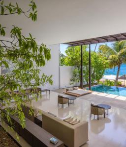 a living room with a couch and chairs and a pool at Three Gables Boutique Villa in Mirissa