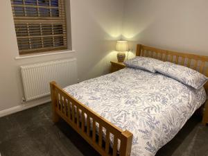a bedroom with a bed with a blue and white comforter at Pointer Cottage in Preesall