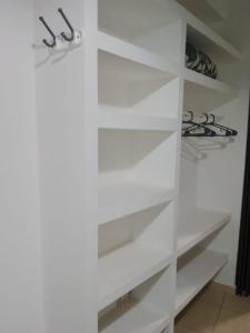 a white closet with white shelves at 4 soles in San Juan