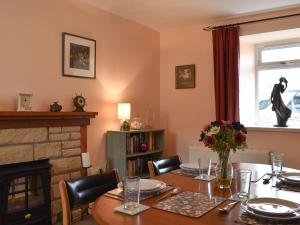 Tradewinds في Portknockie: غرفة طعام مع طاولة ومدفأة