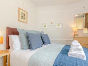 una camera da letto con un grande letto con cuscini blu e bianchi di Number 1 Admiralty Cottages ad Alverstoke