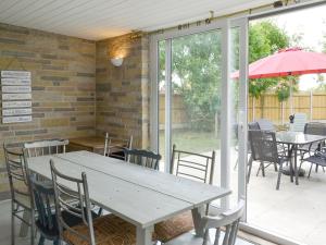 einen Tisch, Stühle und einen Regenschirm auf einer Terrasse in der Unterkunft 185 Golf Road in Mablethorpe