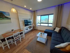a living room with a blue couch and a table at Rotem Suite in MARINA ASHKLON in Ashqelon