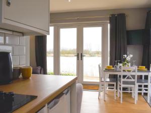 a kitchen and living room with a table and chairs at Hare Lodge - Uk30604 in Pidley