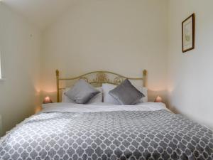 um quarto com uma cama grande e 2 almofadas em Lupton Hall Cottages em Lupton