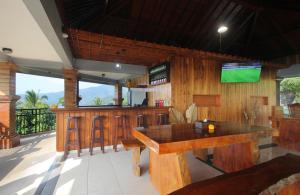 a kitchen with a bar with a television on the wall at Rostika Hotel & Camping Sekumpul in Buleleng