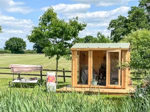 a small cabin in a field with a fence at Lotties Luxurious Lodge - Uk36784 in Sutton Valence