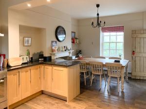 a kitchen with a table and a dining room at Ivy Cottage in Grosmont