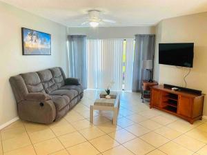 a living room with a couch and a flat screen tv at Shining Star in West Palm Beach