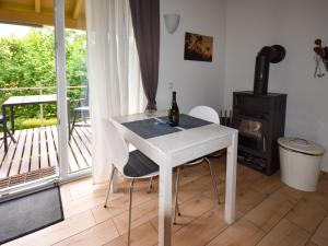 a white table and chairs in a room with a balcony at Beautiful holiday home in the middle of nature in Berlingen