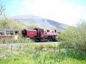 a red train is traveling down the tracks at Seion - Hw7575 in Llanddeiniolen