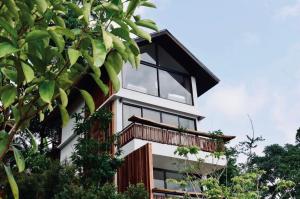 a house with black windows and a balcony at Baan Nhuer Mek บ้านเหนือเมฆ Coffee and Desk on the Cloud 