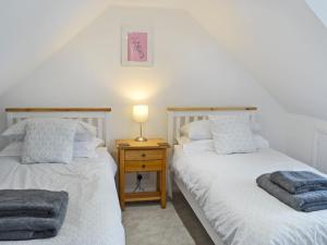 duas camas individuais num quarto com mesa de cabeceira em Altbeg em Brodick