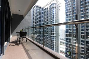 ein Balkon mit Tisch und Blick auf hohe Gebäude in der Unterkunft Atlantis Executive Melaka By I Housing in Malakka