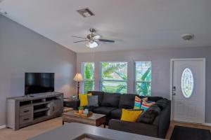 ein Wohnzimmer mit einem Sofa und einem Flachbild-TV in der Unterkunft Beautiful Pool Home with Sleeping for 8 for LovelyPeople in Cape Coral
