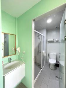 een badkamer met een toilet, een wastafel en een douche bij 35.5 Inn in Kenting