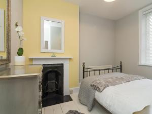 a bedroom with a bed and a fireplace at Coastguard Retreat in Ramsgate