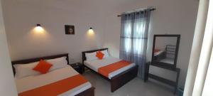 a small bedroom with two beds and a mirror at Lake Edge Resort in Anuradhapura